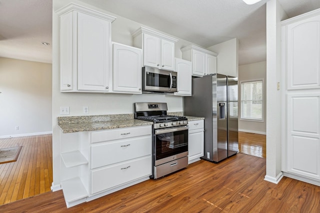 334 Idaho Springs Rd, Clarksville, TN 37043 - kitchen featuring light stone counters, white cabinetry, stainless steel appliances, baseboards, and dark wood-style flooring
