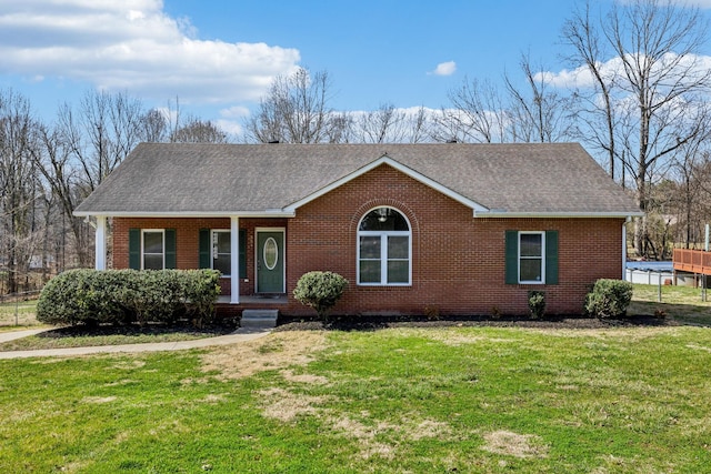 single story home featuring brick siding, roof with shingles, covered porch, and a front lawn