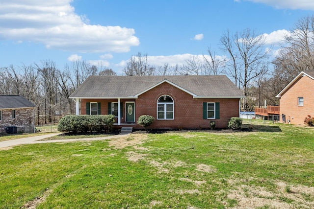 view of front of home with brick siding, covered porch, a shingled roof, and a front yard