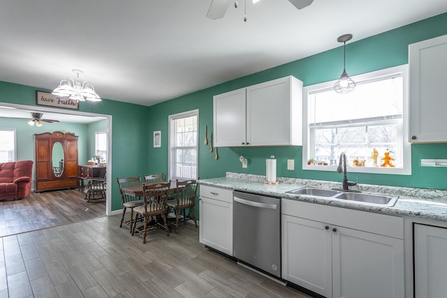 kitchen with ceiling fan with notable chandelier, a sink, light wood-style floors, dishwasher, and hanging light fixtures