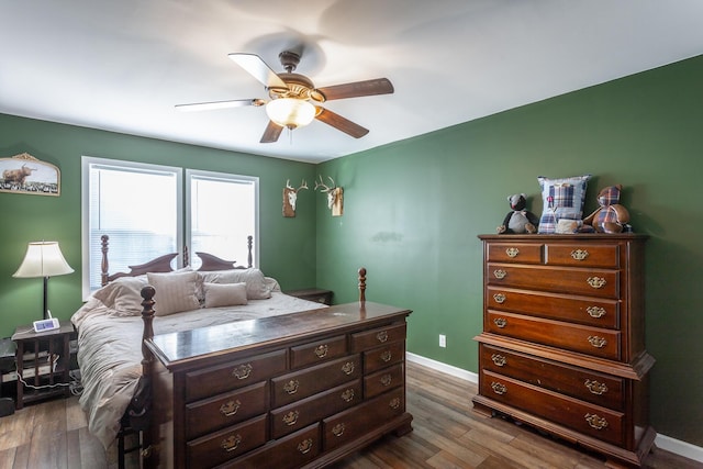 bedroom with a ceiling fan, dark wood-type flooring, and baseboards