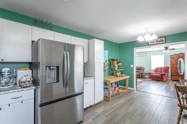 kitchen with light wood-style flooring, white cabinetry, ceiling fan with notable chandelier, and stainless steel fridge with ice dispenser