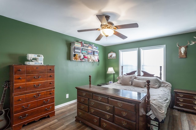 bedroom with ceiling fan, dark wood-type flooring, and baseboards