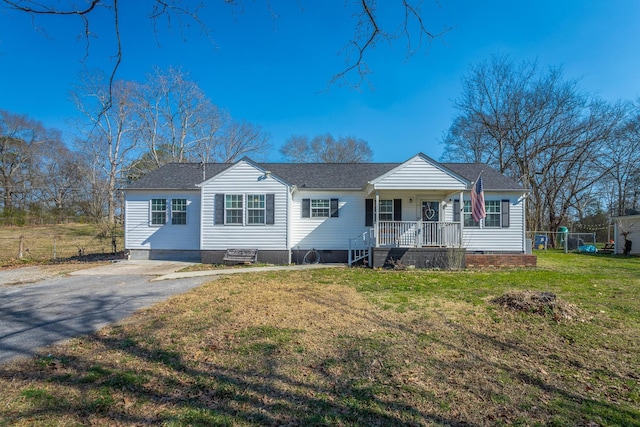 view of front of home with a porch, a front yard, roof with shingles, and crawl space