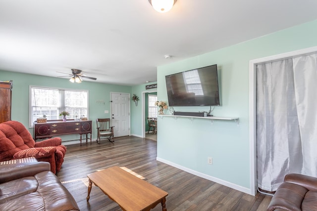 living room featuring baseboards, ceiling fan, and dark wood-style flooring