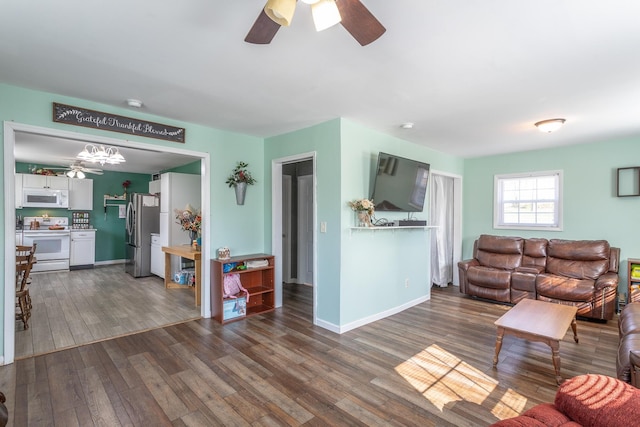 living area with wood finished floors, baseboards, and ceiling fan