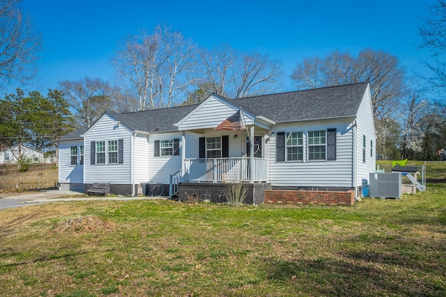 bungalow-style home featuring a front yard, covered porch, central AC, and a shingled roof