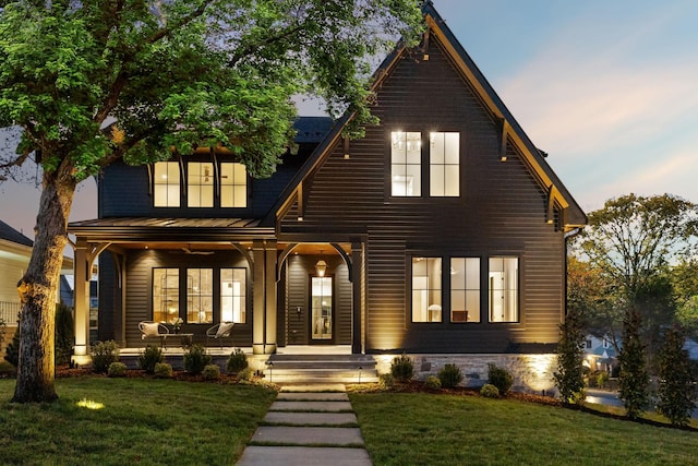 view of front of home with a porch and a front lawn