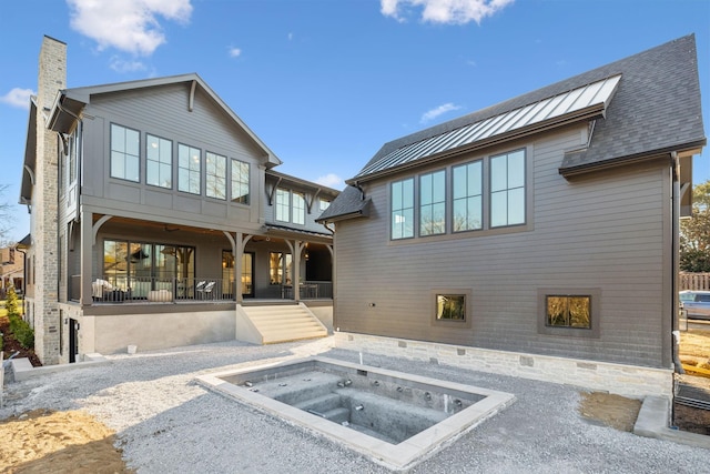 back of house featuring an in ground hot tub and a chimney