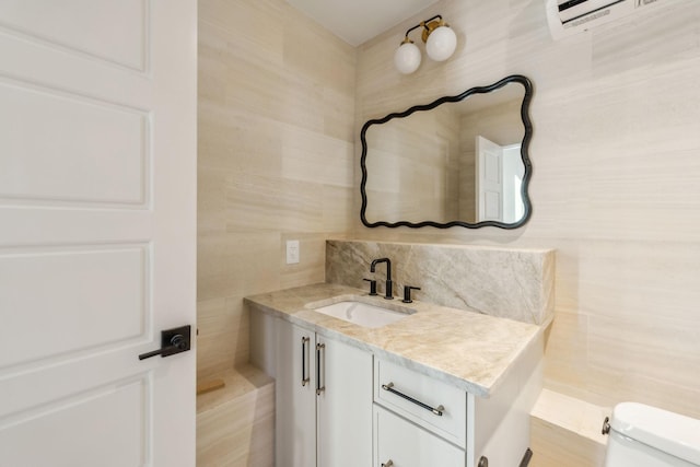 bathroom with vanity, tile walls, toilet, and a wall mounted air conditioner