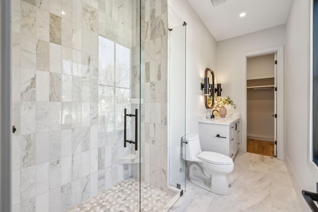 full bathroom featuring a spacious closet, toilet, a stall shower, and vanity