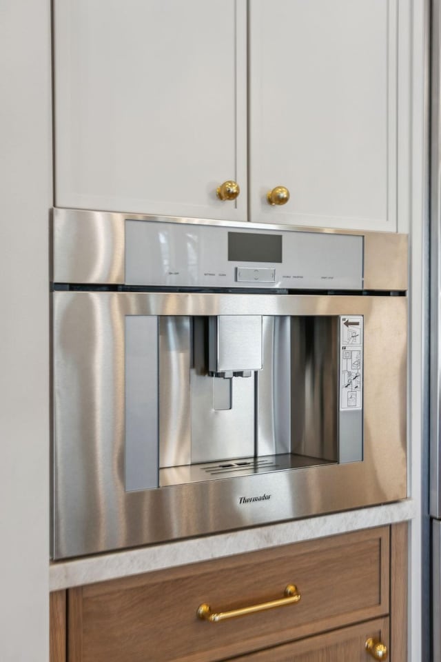 details with brown cabinetry, light countertops, and stainless steel oven