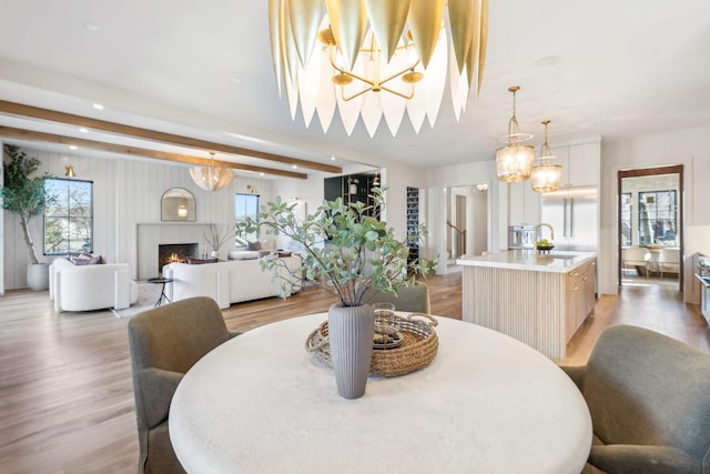 dining room featuring light wood-type flooring, plenty of natural light, and an inviting chandelier