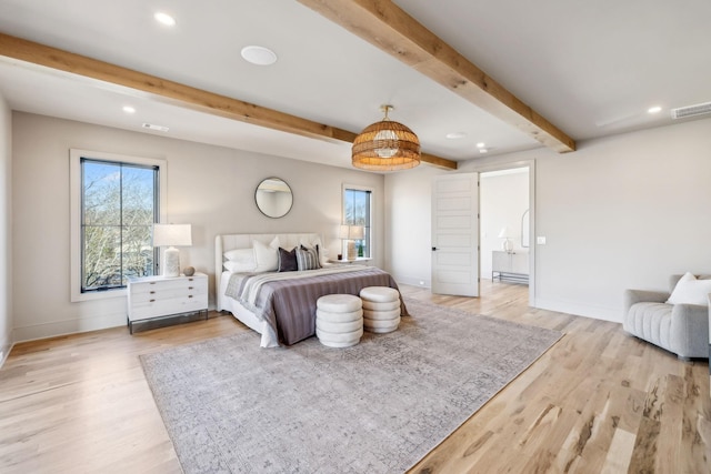 bedroom with beam ceiling, multiple windows, visible vents, and light wood finished floors