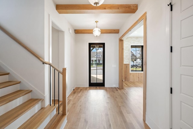 entrance foyer featuring beam ceiling, stairs, light wood-type flooring, and baseboards