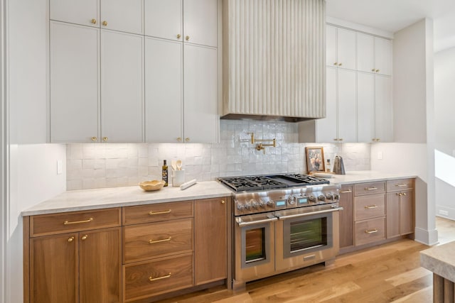 kitchen with decorative backsplash, double oven range, and light wood-type flooring