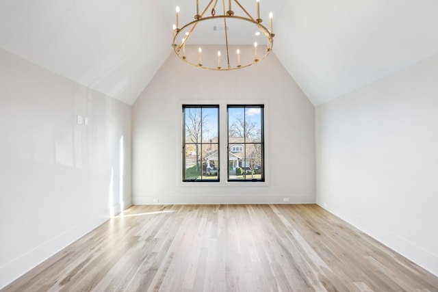 bonus room with baseboards, light wood-style floors, and an inviting chandelier