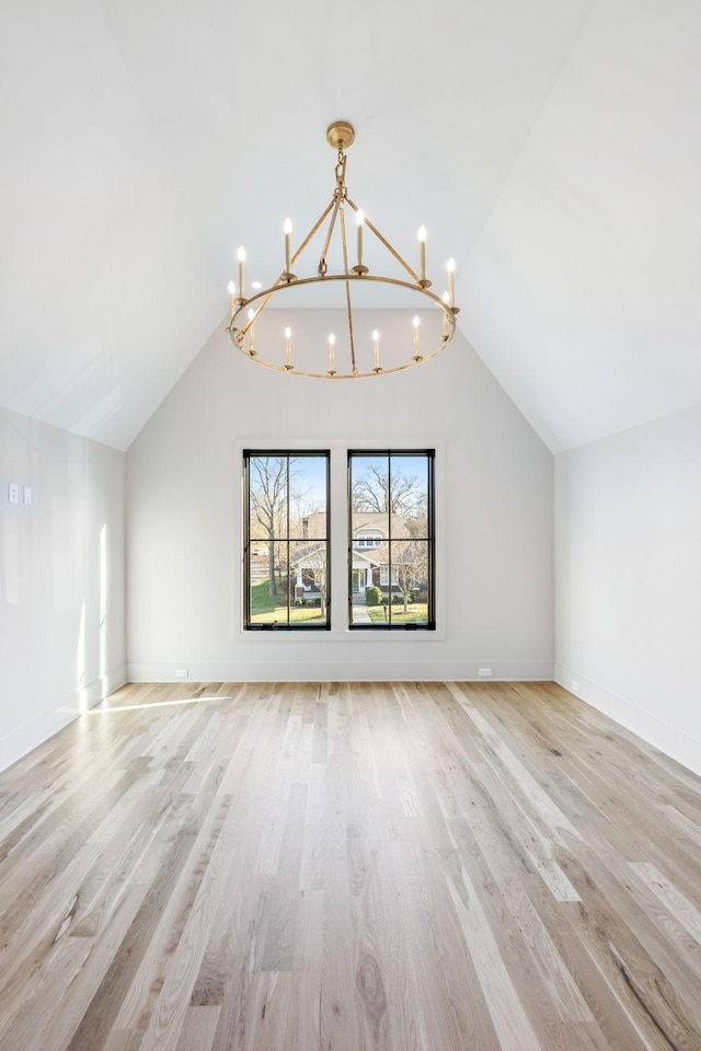 bonus room with vaulted ceiling, light wood-style flooring, and a chandelier