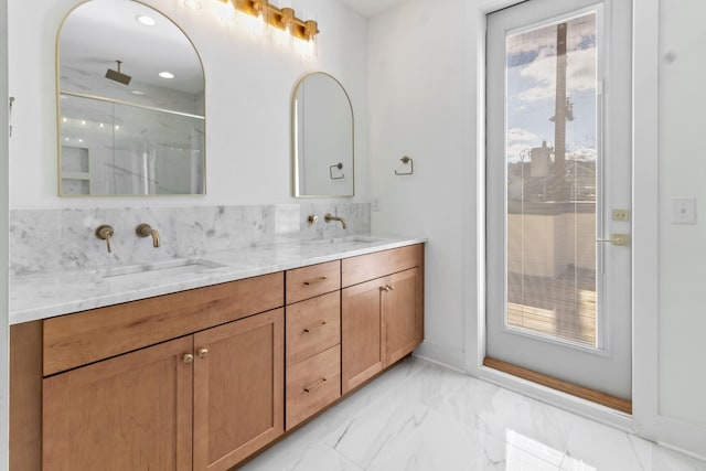 bathroom with a marble finish shower, marble finish floor, double vanity, and a sink