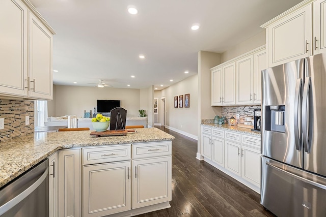 kitchen with dark wood-type flooring, a ceiling fan, recessed lighting, stainless steel appliances, and a peninsula