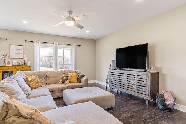 living area featuring baseboards, ceiling fan, and wood finished floors