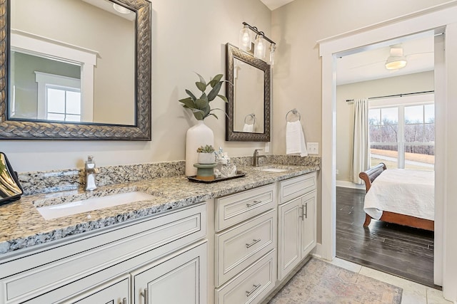 ensuite bathroom with double vanity, baseboards, ensuite bathroom, and a sink