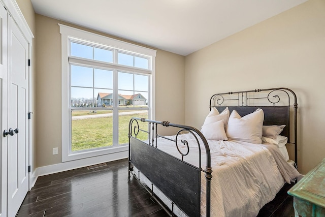 bedroom featuring dark wood-style floors, visible vents, and baseboards