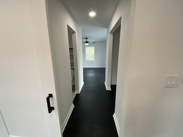 corridor with baseboards and dark wood-style floors