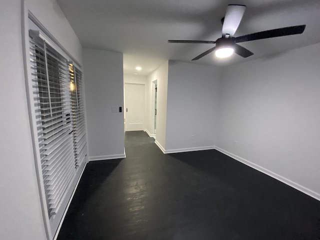 unfurnished room with a ceiling fan, concrete floors, and baseboards