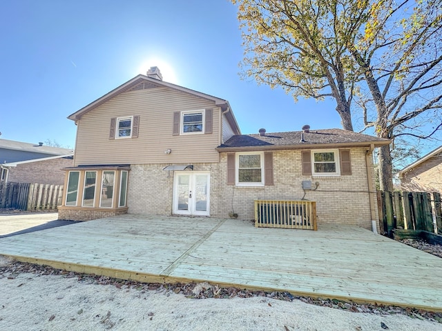 back of house with a wooden deck, brick siding, french doors, and fence