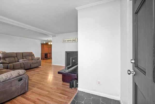 living area featuring crown molding, wood finished floors, and baseboards