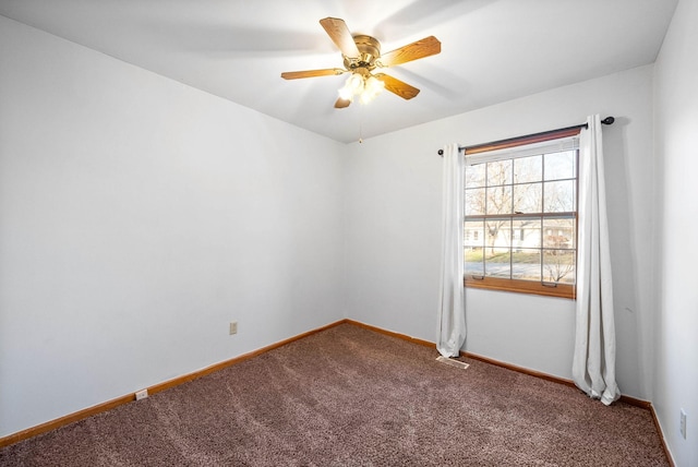 carpeted spare room featuring visible vents, baseboards, and a ceiling fan