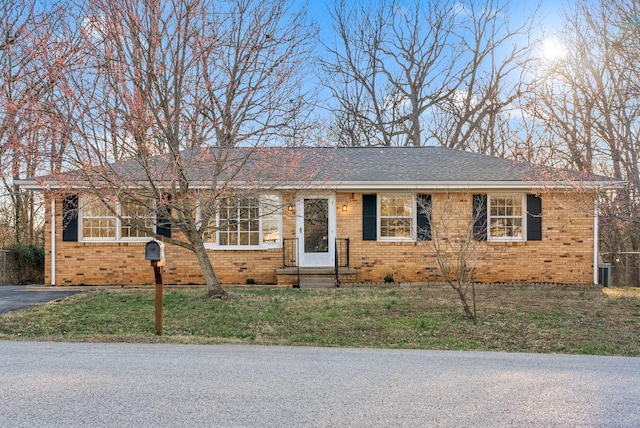 ranch-style home featuring brick siding and a front lawn