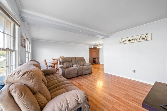 living area with an inviting chandelier, light wood-style flooring, baseboards, and ornamental molding