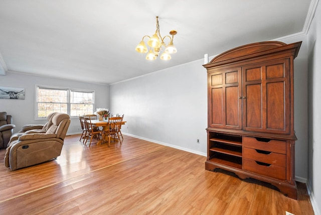 dining room featuring a notable chandelier, baseboards, crown molding, and light wood-style floors