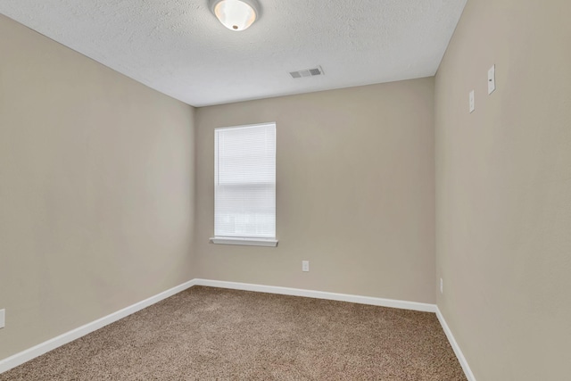 carpeted empty room featuring visible vents, a textured ceiling, and baseboards