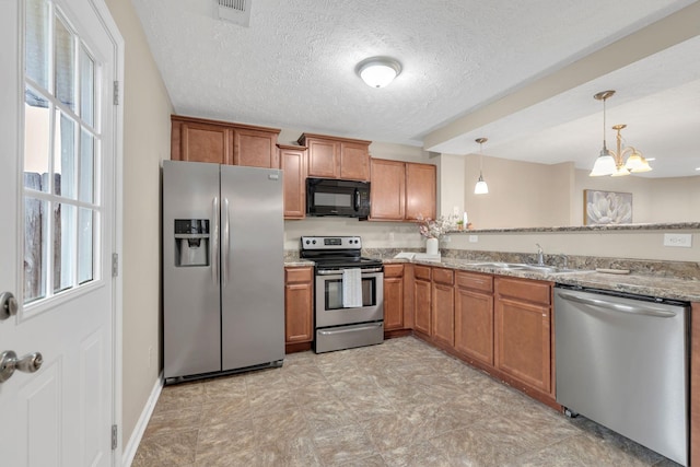 kitchen featuring brown cabinetry, appliances with stainless steel finishes, and a sink