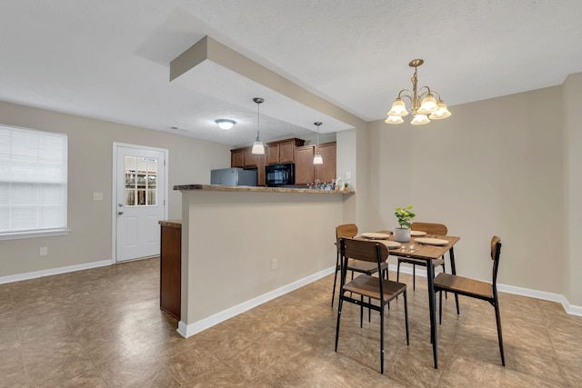 dining room featuring baseboards and a notable chandelier