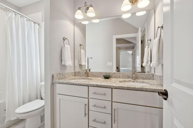 full bath featuring double vanity, toilet, and a sink