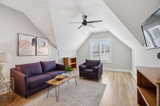 living area featuring baseboards, lofted ceiling, ceiling fan, and light wood finished floors