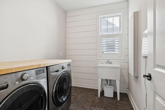 washroom with wooden walls, independent washer and dryer, laundry area, and baseboards