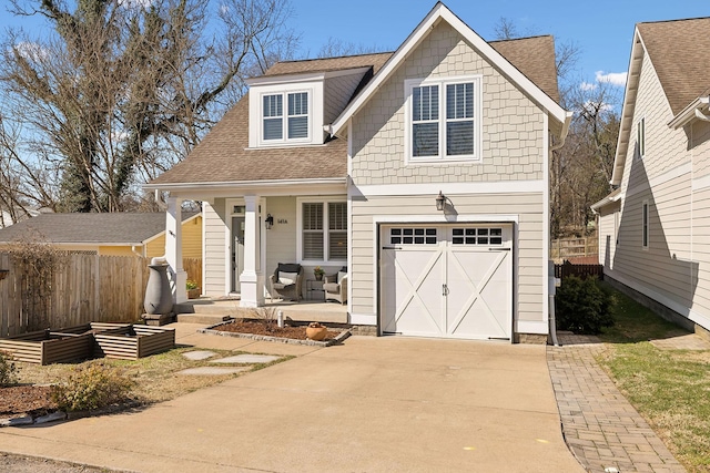 view of front of house with driveway, fence, covered porch, a vegetable garden, and a shingled roof