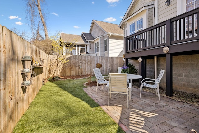 view of yard with a fenced backyard, outdoor dining space, and a patio area