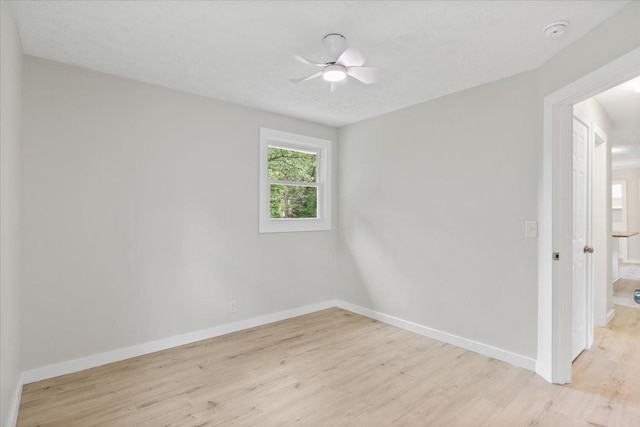 unfurnished room with ceiling fan, baseboards, and light wood-style floors