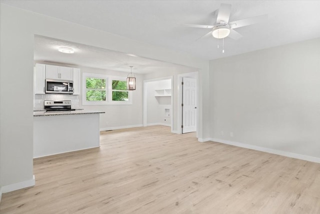 unfurnished living room with light wood-type flooring, baseboards, and ceiling fan