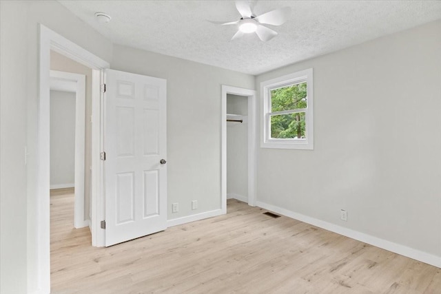 unfurnished bedroom with a textured ceiling, baseboards, visible vents, and light wood-type flooring