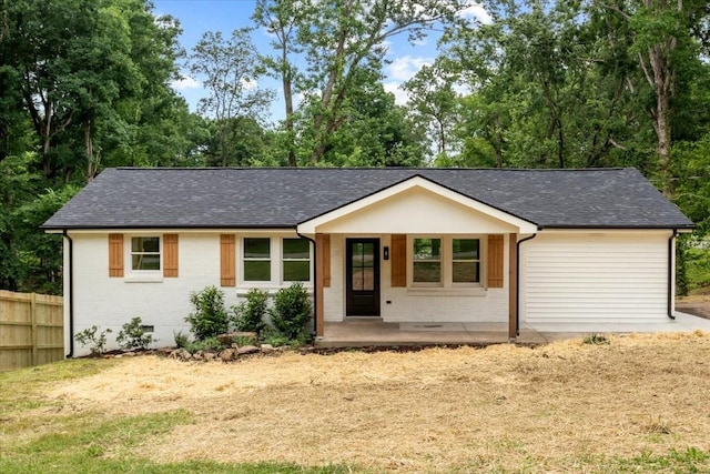 ranch-style home with fence, brick siding, and a shingled roof