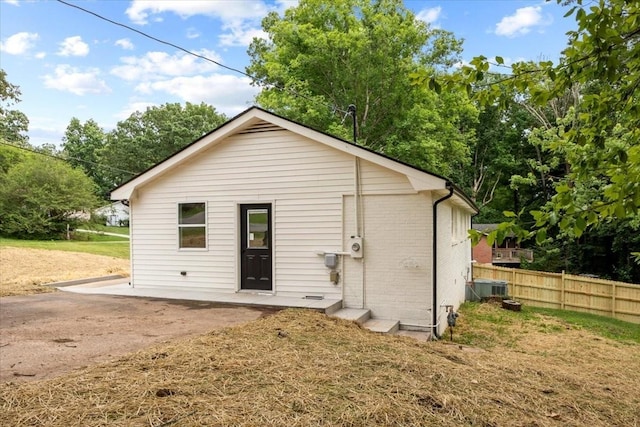 rear view of house featuring fence and brick siding