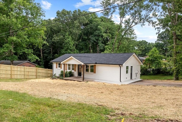 ranch-style house with fence, driveway, and roof with shingles