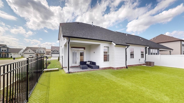 rear view of house featuring an outdoor living space, a fenced backyard, a yard, a residential view, and a shingled roof